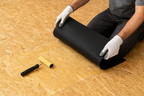 Black roofing membrane placed on plywood during installation