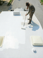 RV roof coating primer applied on a flat roof using a roller, tray, and brush