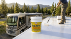 RV roof coating can and applicator brush on a large white roof panel